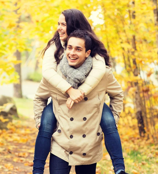 Sonriente pareja divirtiéndose en el parque de otoño Fotos de stock libres de derechos