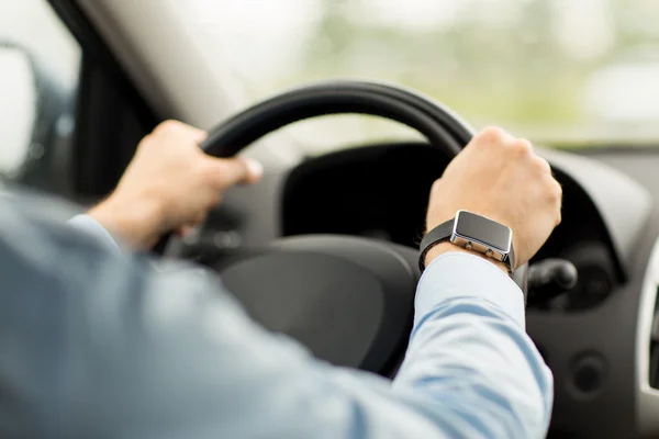 Close up of man with wristwatch driving car Stock Photo