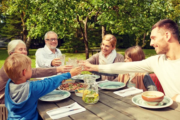 Lycklig familj äter middag i sommarträdgård — Stockfoto