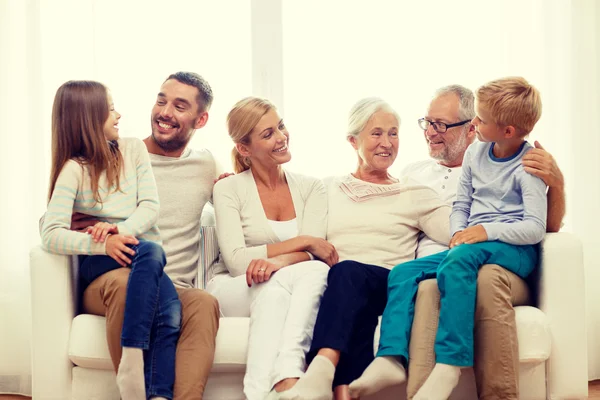 Familia feliz sentada en el sofá en casa — Foto de Stock