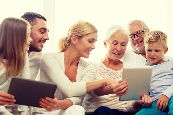 Família sorrindo com tablet pc em casa — Fotografia de Stock