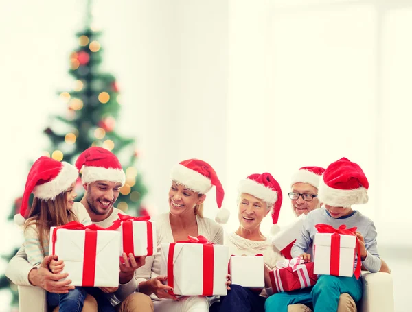 Santa yardımcı şapka hediye kutuları ile mutlu bir aile — Stok fotoğraf