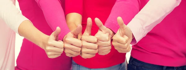 Primer plano de las mujeres en camisas de color rosa mostrando pulgares hacia arriba —  Fotos de Stock