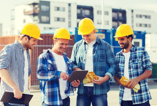 Grupo de construtores sorridentes com tablet pc ao ar livre — Fotografia de Stock