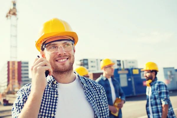 Csoport mosolygó építők, hardhats rádió — Stock Fotó