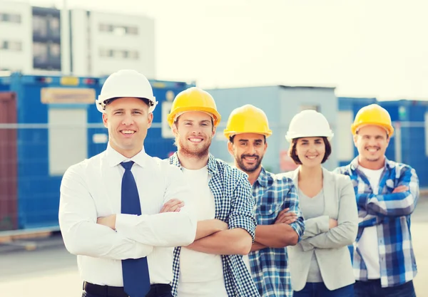 Mosolygó építők, szabadban hardhats csoportja — Stock Fotó