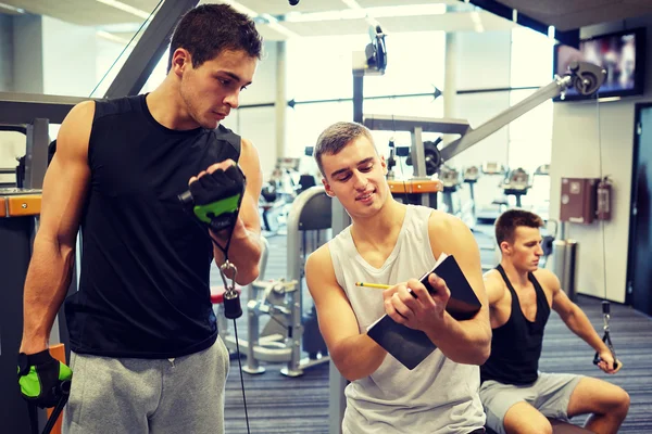 Men exercising on gym machine — Stock Photo, Image