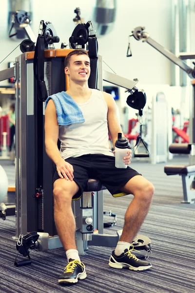 Hombre sonriente haciendo ejercicio en la máquina de gimnasio — Foto de Stock