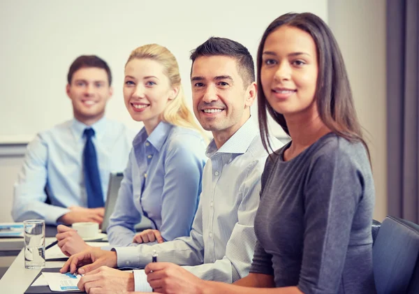 Grupo de empresarios sonrientes reunidos en el cargo — Foto de Stock