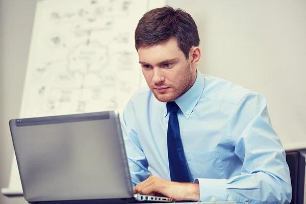 Uomo d'affari seduto con computer portatile in ufficio — Foto Stock