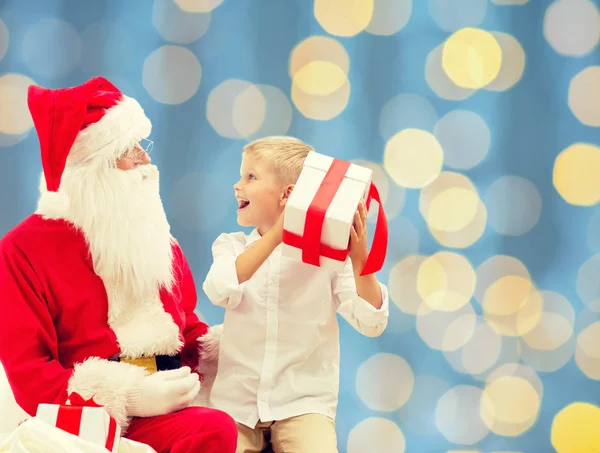 Smiling little boy with santa claus and gifts — Stock Photo, Image