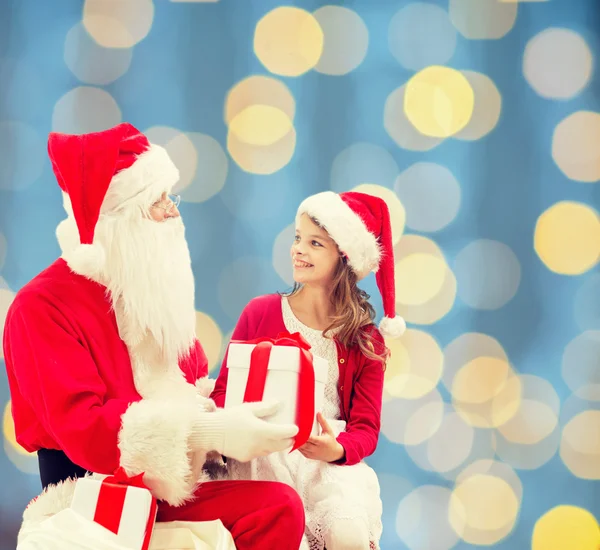 Lachende meisje met santa claus en giften — Stockfoto