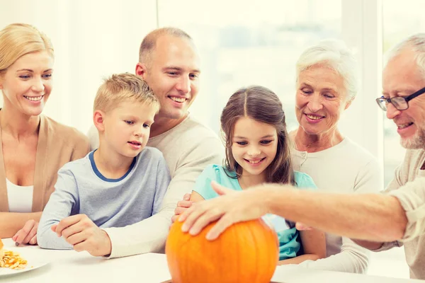 Happy family sitting with pumpkins at home — Stock Photo, Image