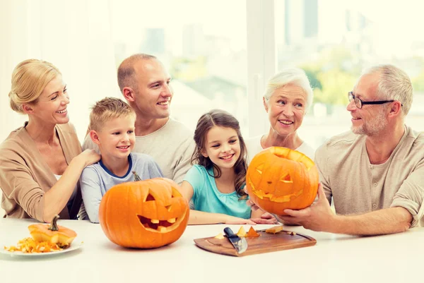 Familia feliz sentado con calabazas en casa —  Fotos de Stock