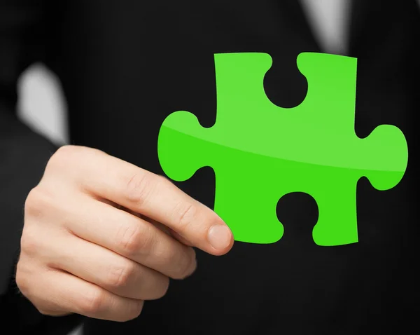 Close up of man holding green puzzle piece — Stock Photo, Image