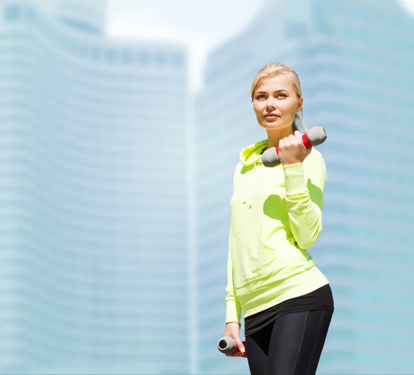 Sporty woman with light dumbbells outdoors — Stock Photo, Image