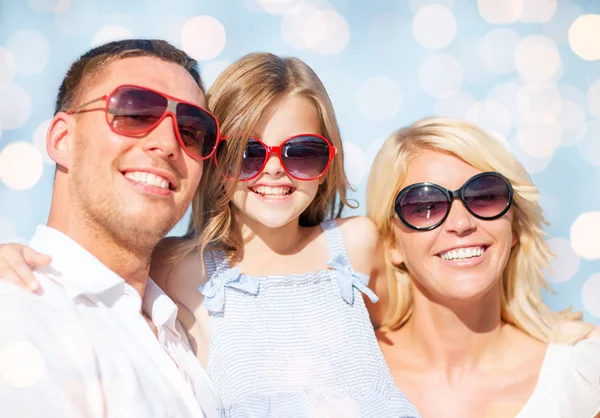 Família feliz sobre luzes azuis fundo — Fotografia de Stock