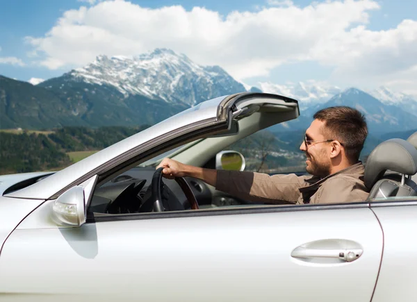 Felice uomo guida cabriolet auto oltre le montagne — Foto Stock