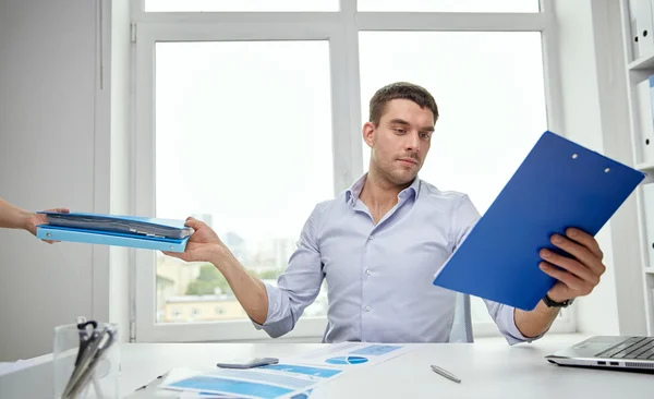 Geschäftsmann nimmt Sekretärin Papiere ab — Stockfoto