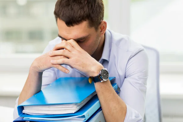 Sad businessman with stack of folders at office — Stock Photo, Image