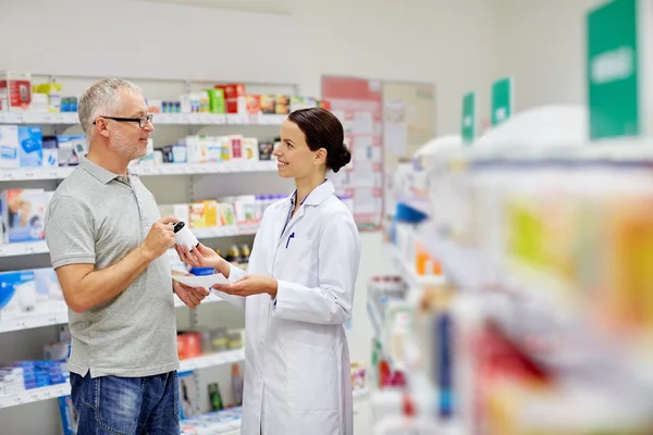 Farmacêutico e homem sênior comprando droga na farmácia — Fotografia de Stock
