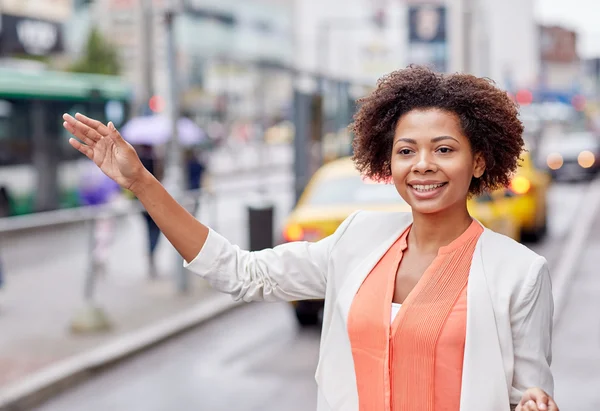 Happy african woman catching taxi — Stock Photo, Image