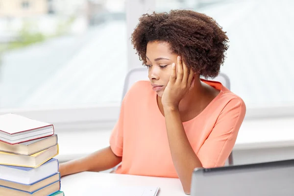 Mujer afroamericana aburrida haciendo la tarea en casa —  Fotos de Stock