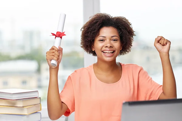 Happy afrikansk kvinna med laptop, böcker och diplom — Stockfoto