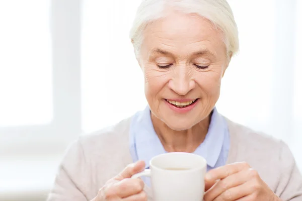 Felice donna anziana con tazza di tè o caffè — Foto Stock