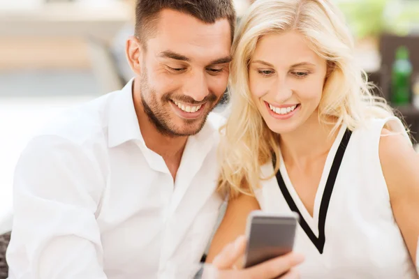 Happy couple with smartphone at city street cafe — Stock Photo, Image