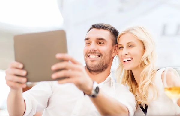 Feliz pareja con tablet pc en el salón del restaurante —  Fotos de Stock