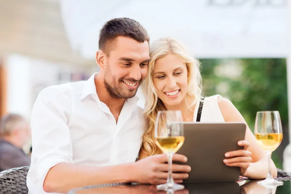 Gelukkige paar met de tablet pc in restaurant lounge — Stockfoto