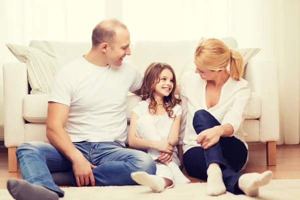 Föräldrar och liten flicka sitter på golvet hemma — Stockfoto