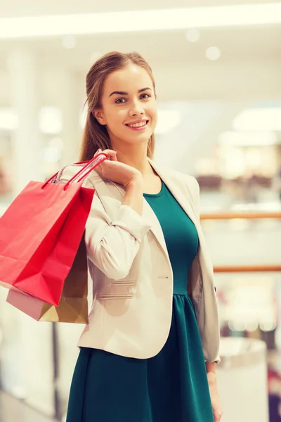 Glückliche junge Frau mit Einkaufstüten in Einkaufszentrum — Stockfoto