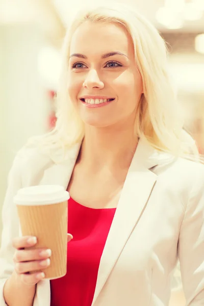 Glad ung kvinna med kaffe papper kopp i gallerian — Stockfoto