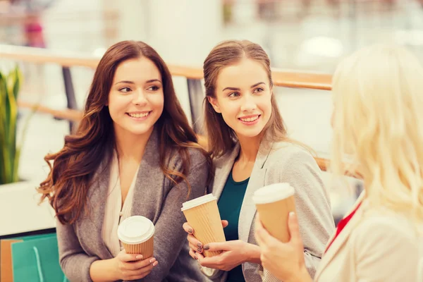 Jonge vrouwen met shopping tassen en koffie in winkelcentrum — Stockfoto
