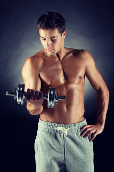 Jonge man met dumbbell Stockfoto