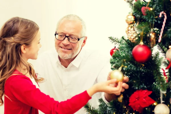 Smiling family decorating christmas tree — Stock Photo, Image