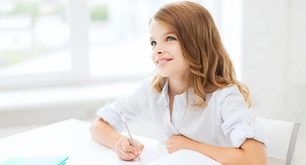 Dziewczyna studentów pisania w notesie w szkole — Zdjęcie stockowe