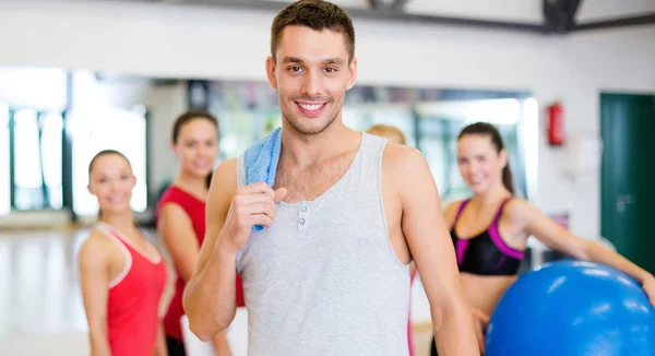 Hombre de pie delante del grupo en el gimnasio — Foto de Stock