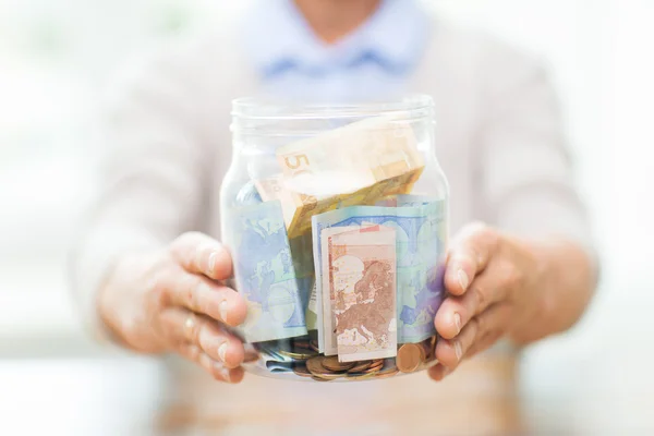 Close up van senior vrouw met geld in glazen pot — Stockfoto