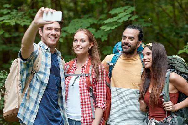 Amigos con mochila tomando selfie por teléfono inteligente —  Fotos de Stock