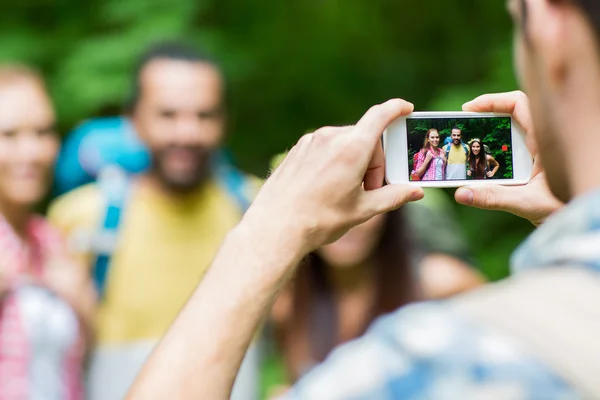 Man fotograferar vänner av smartphone — Stockfoto