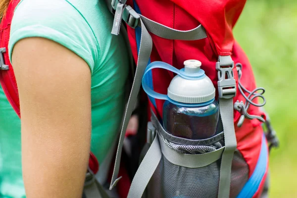 Close up of woman with water bottle in backpack — Stock Photo, Image