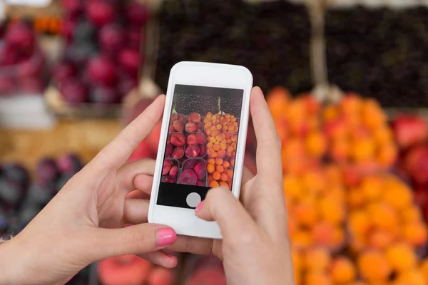 Mãos com smartphone tirando fotos de frutas — Fotografia de Stock