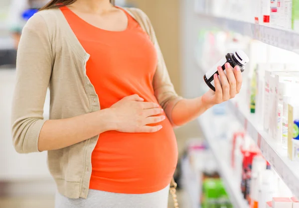 Zwangere vrouw met medicatie bij apotheek — Stockfoto