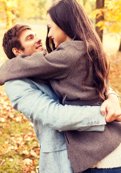 Casal sorridente abraçando no parque de outono — Fotografia de Stock