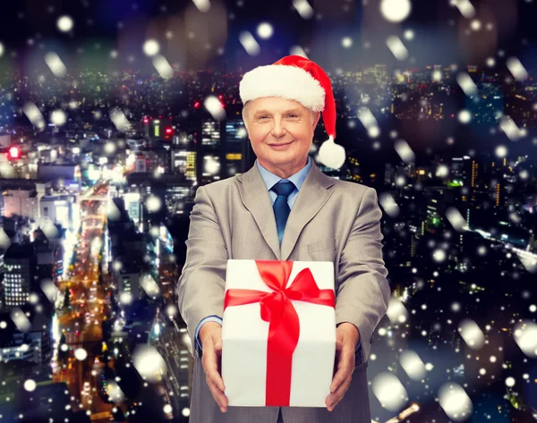 Man in suit and santa hat with gift — Stock Photo, Image