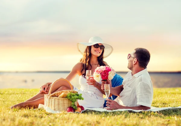 Усміхнена пара п'є шампанське на пікніку — стокове фото