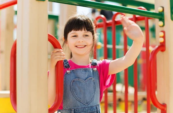 Fröhliches kleines Mädchen klettert auf Kinderspielplatz — Stockfoto